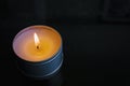 Soy wax tin candle lit in a dark room Royalty Free Stock Photo
