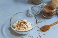 Soy yogurt with flax and sunflower seeds in a glass bowl on a blue background close-up