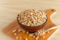 Soybean in a bowl with wooden chopping board and spoon on wooden background, front view, selective focus Royalty Free Stock Photo