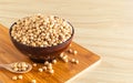 Soybean in a bowl with wooden chopping board and spoon on wooden background, front view, selective focus Royalty Free Stock Photo