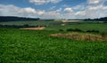 Soybean field hills out of focus, waves of fields on horizon with beautiful cloudy sky