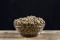Soybeans on the glass bowl with black and woooden table background