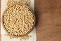 Soybeans in wooden bowl putting on linen and wooden background
