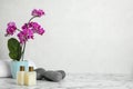 Spa accessories and blooming orchid on  table against light background, space for text Royalty Free Stock Photo