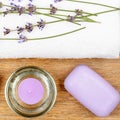 SPA accessories: lavender soap, scented candle, dried lavender flowers and a towel on a wooden Royalty Free Stock Photo