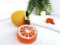 Close up essential oil bottle with orange soap on white wooden background. Royalty Free Stock Photo