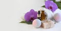 Spa aromatherapy composition with essential oil bottle dropper, bath bomb, soap bar and orchid flowers. Royalty Free Stock Photo