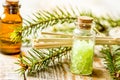 Spa with organic spruce oil and sea salt in glass bottles on wooden table background