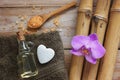 Spa background with bamboo, bath salt, massage oil, orchid flower, towel and stone in the shape of heart