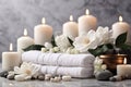 Spa background in a brown shade - white towels, aroma candles, stones for a relaxing massage and white flowers