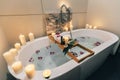 Spa bath with flowers, candles and tray Royalty Free Stock Photo