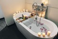 Spa bath with flowers, candles and tray Royalty Free Stock Photo