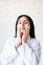 Happy beautiful middle eastern woman wearing bath towels applying facial cream on her face Royalty Free Stock Photo