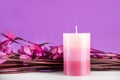 Spa composition with aromatic candle and purple flowers and branches on desk Royalty Free Stock Photo