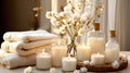 Spa composition with aromatic candles, towels and cotton flowers on table in room. Beauty spa treatment and relax concept