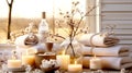 Spa composition with aromatic candles, towels and cotton flowers on table in room. Beauty spa treatment and relax concept