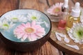 Spa composition. Bowl with water and beautiful flowers on wooden table, closeup. Space for text