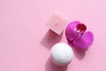 Spa composition with Bubble Bath Bomb, candle and orchid flower on pink background. Pink salt bomb on pastel backdrop. Royalty Free Stock Photo