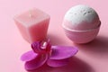 Spa composition with Bubble Bath Bomb, candle and orchid flower on pink background. Pink salt bomb on pastel backdrop. Royalty Free Stock Photo