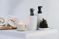 Spa composition with burning candle, towels and bottles on white background. Royalty Free Stock Photo