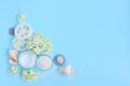 Spa composition with cream, salt, shells and flowers on a blue background