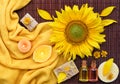 Spa composition with natural soap, candles, aroma oils in bottles and sunflower on bamboo mat