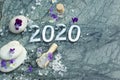 Spa composition 2020 with purple flowers, candles, stones and sea bath salt Royalty Free Stock Photo