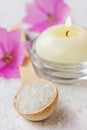 Spa composition with sea salt bath in wooden spoon, pink flowers and burning candles Royalty Free Stock Photo
