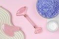 Spa composition with selective focus. Pink jade facial massager on pink background Royalty Free Stock Photo