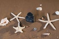 Spa composition - stacked Basalt Stones, Seashells and Sea Stars on the beach at sunrise in front of the ocean. Royalty Free Stock Photo