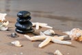 Spa composition - stacked Basalt Stones, Seashells and Sea Stars on the beach at sunrise in front of the ocean. Royalty Free Stock Photo