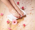 female feet, a white towel and petals on the floor Royalty Free Stock Photo