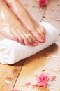 female feet, a white towel and petals on the floor Royalty Free Stock Photo