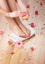 female feet, a white towel and petals on the floor Royalty Free Stock Photo