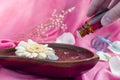 spa concept background with a white daisy and essential oil dripper on pink background Royalty Free Stock Photo