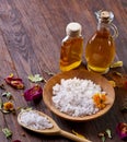 SPA concept: composition of spa treatment with natural sea salt, aromatic oil and flowers on wooden background Royalty Free Stock Photo