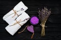 Spa concept. Lavender salt for a relaxing bath, handmade soap, white towels and dry lavender flowers on a black wooden background Royalty Free Stock Photo