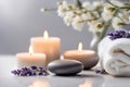 Spa concept, massage stone with towels, candles and lavender and white flowers. Royalty Free Stock Photo