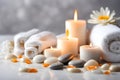 Spa concept, massage stones with towels, candles and daisy flowers.