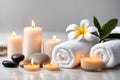 Spa concept, massage stones with towels, candles and frangipani flowers. Royalty Free Stock Photo