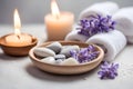 Spa concept, massage stones with towels, candles and lavender flowers.