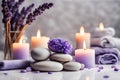 Spa concept, massage stones with towels, candles and lavender and purple wild flowers. Royalty Free Stock Photo