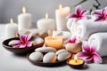 Spa concept, massage stones with towels, candles and frangipani flowers. Royalty Free Stock Photo