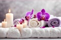 Spa concept, massage stones with towels, candles and purple orchids. Royalty Free Stock Photo
