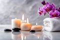 Spa concept, massage stones with towels, candles and purple orchids. Royalty Free Stock Photo