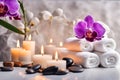 Spa concept, massage stones with towels, candles and purple orchids. Royalty Free Stock Photo