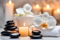 Spa concept, massage stones with towels, candles and white orchids. Royalty Free Stock Photo