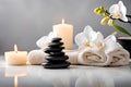 Spa concept, massage stones with towels, candles and white orchids. Royalty Free Stock Photo