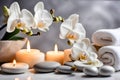 Spa concept, massage stones with towels, candles and white orchids. Royalty Free Stock Photo