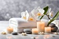 Spa concept, massage stones with towels, candles and white orchids. Royalty Free Stock Photo